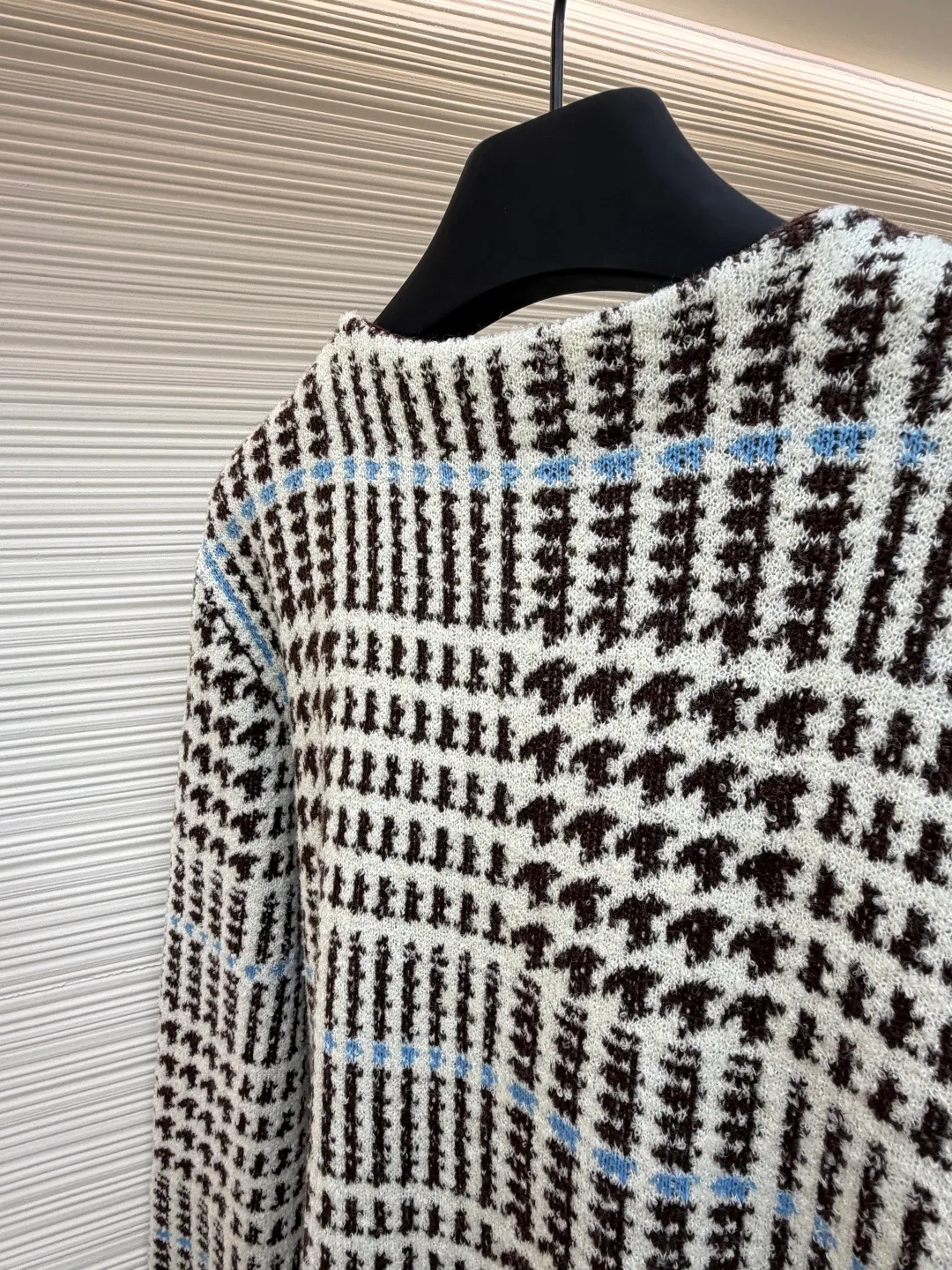 LOUIS VUITTON letter intarsia houndstooth knitted jacquard cardigan ●Original version: purchased and developed by 14743 ●Item number: 1681873-C00 ●Fabric: wool blended fabric ●Technology: jacquard knitting ●Color: black, white and blue ●Version: fitted version ●Weight: about 695 grams ●Size: S-M-L-XL ●Description: The main pattern of this cardigan is woven with full-width jacquard technology, using 69% sheep wool blended with 31% nylon yarn to interweave the houndstooth pattern with light blue line texture. At the same time, the brand logo elements are integrated into the body through intarsia technology, and the edges of the pattern are connected delicately and seamlessly. The collar, cuffs and hem are made of 100% sheep wool ribbed fabric, and are edged with double-needle seaming technology, which has both elasticity and shaping effect. The front placket is equipped with natural-textured buttons, and the side seam pockets use invisible stitching technology to blend naturally with the jacquard texture of the body. The overall shape is shaped through three-dimensional tailoring, and the shoulders are stitched with seamless stitching to ensure fit and comfort. The entire piece is finished with handcrafted details in an Italian workshop, showing the craftsmanship precision of high-quality knitted items. The overall wiring is straight and delicate, the fabric is comfortable and soft, and the color is consistent without color difference. It can be matched with the same style to create a fashionable look and control various occasions. Customized accessories, complete with three standards, same style for men and women!